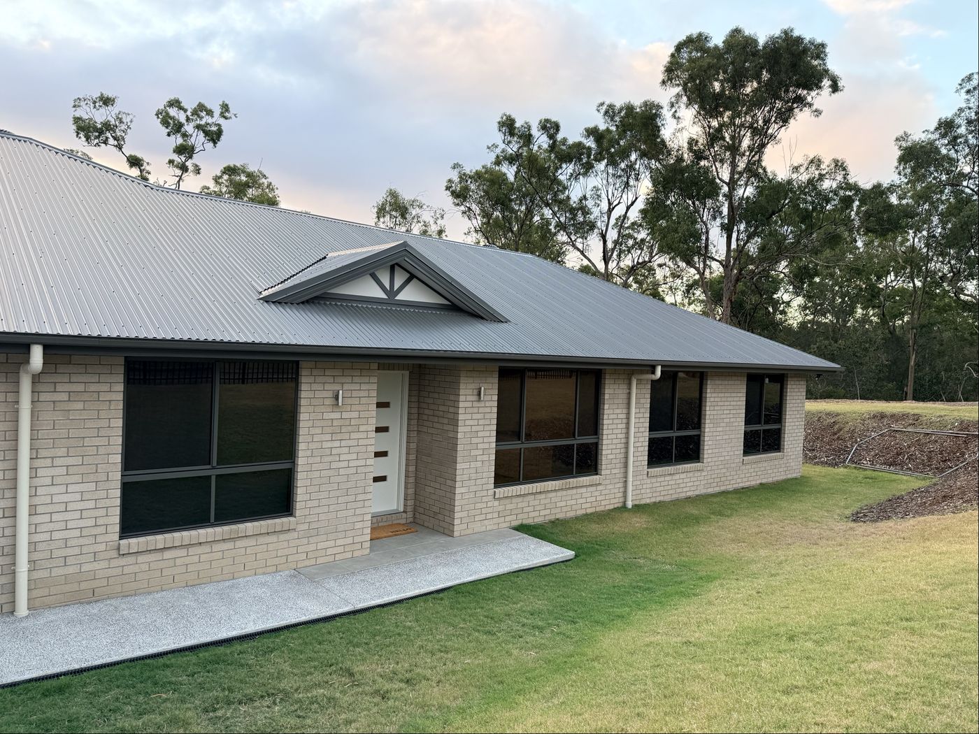 New build window tinting brick home at dusk